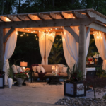 Elegant wooden pergola with string lights and draped curtains in a Fort Worth TX backyard, designed for cozy evening outdoor living