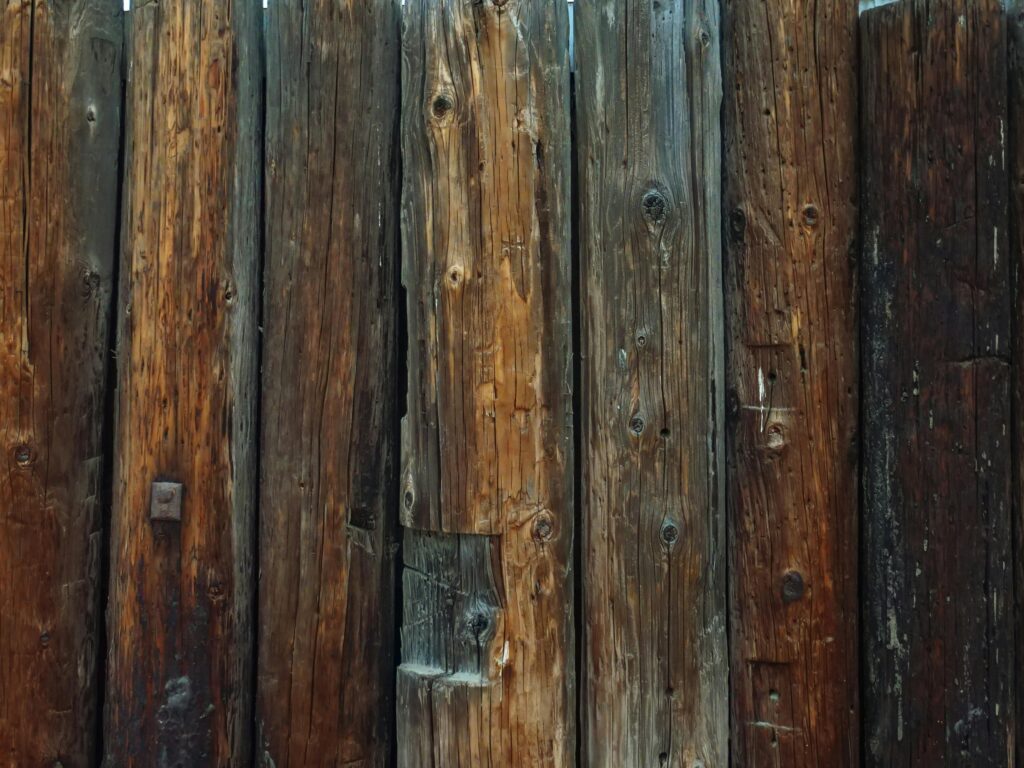 Close-up of a weathered wooden fence in need of staining to preserve durability and enhance appearance in Fort Worth.