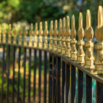 Decorative wrought iron fence with gold accents in a Fort Worth backyard.