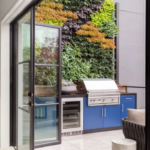 Modern custom outdoor kitchen with vertical garden and stainless steel grill in Texas home.