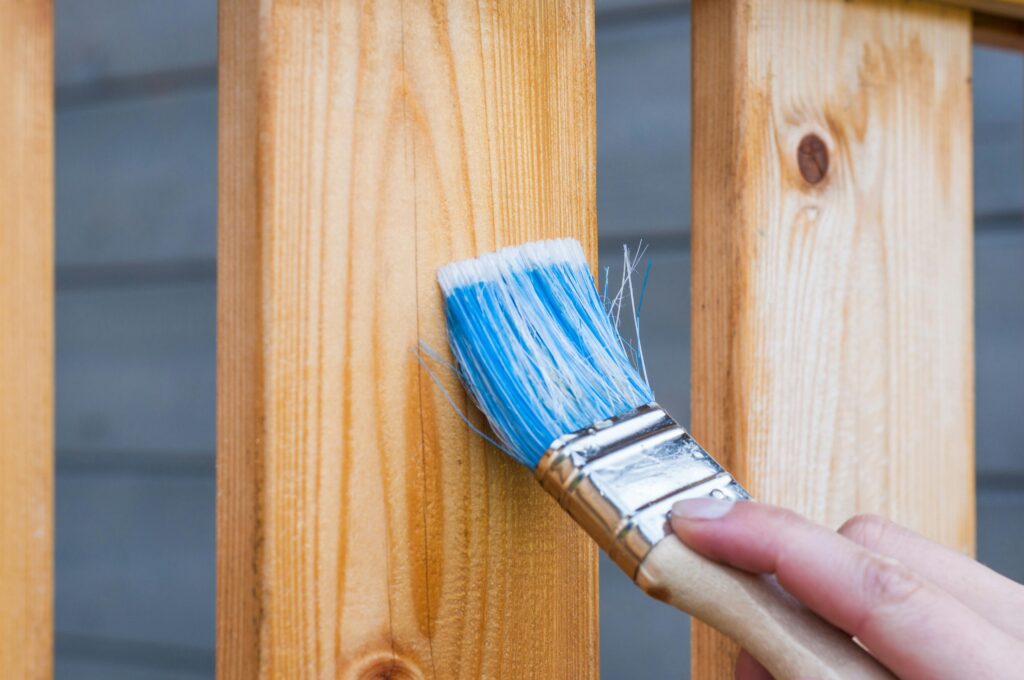 Close-up of fence staining during professional maintenance service.