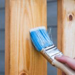 Close-up of fence staining during professional maintenance service.