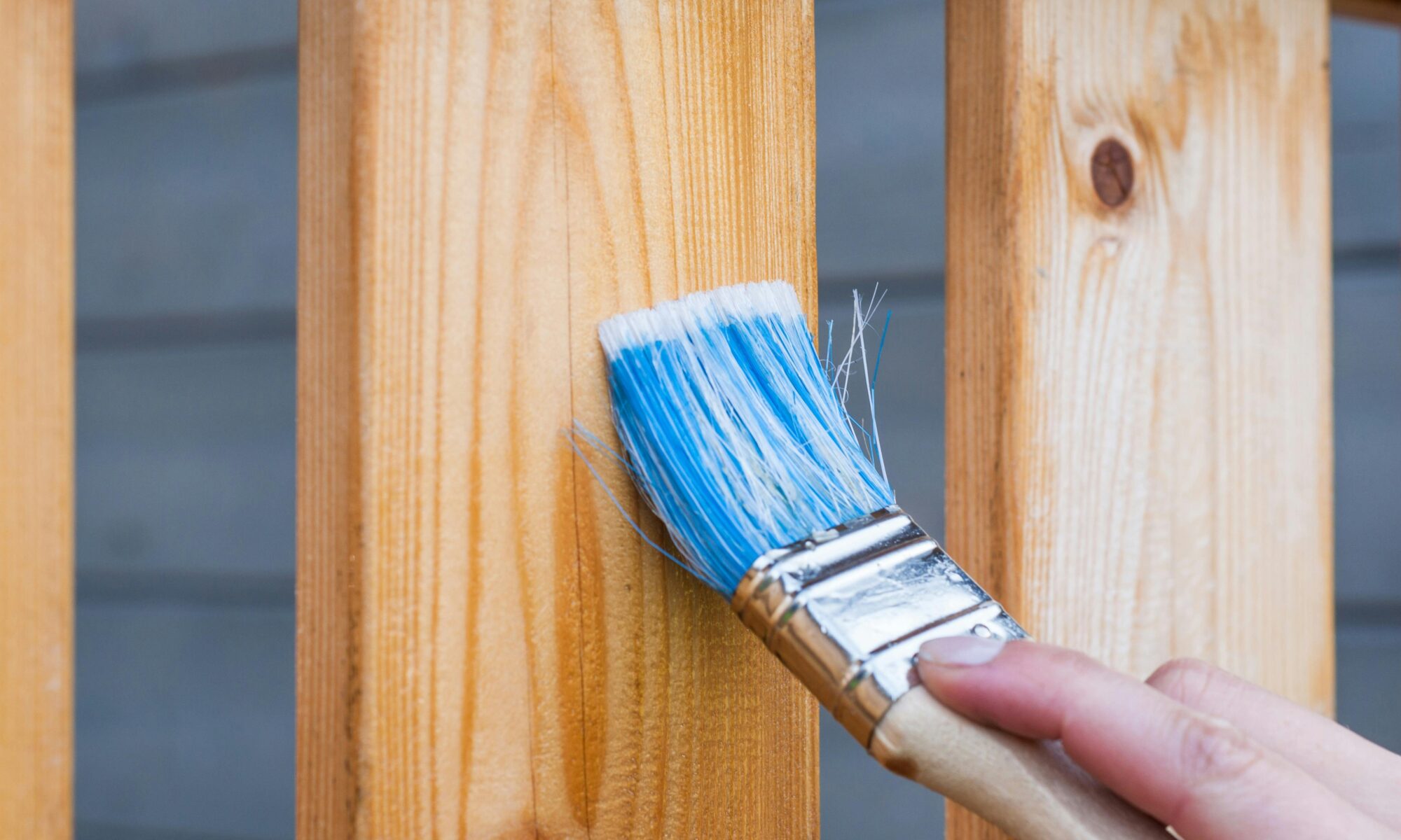 Close-up of fence staining during professional maintenance service.