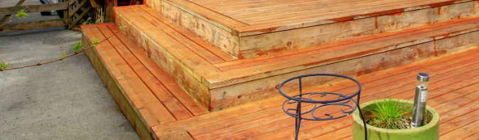Raised wooden patio deck with wide steps, showcasing expert craftsmanship and durable construction in a Texas backyard.