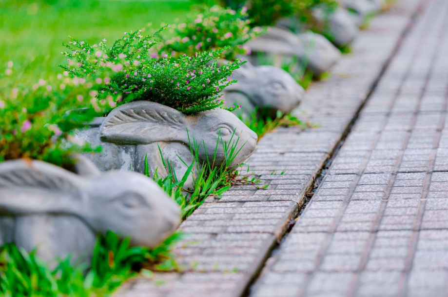 Decorative rabbit-shaped planters lining a garden pathway.