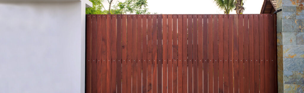 Wood driveway gate requiring regular maintenance for long lifespan in Texas