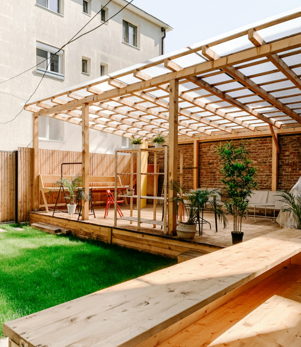 Modern wooden pergola with seating area and greenery in a Fort Worth backyard