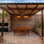 Custom wood pergola patio with brick flooring and outdoor dining area in Fort Worth backyard