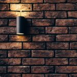 Alt Text: Modern outdoor brick wall with warm lighting. custom stonework inspiration for Fort Worth patios.