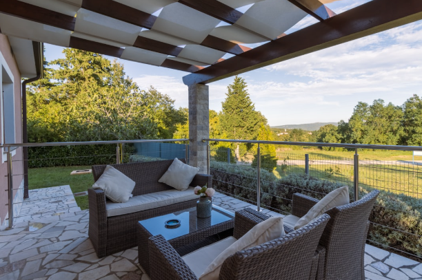 Modern outdoor patio with stone flooring and rattan furniture in Fort Worth home