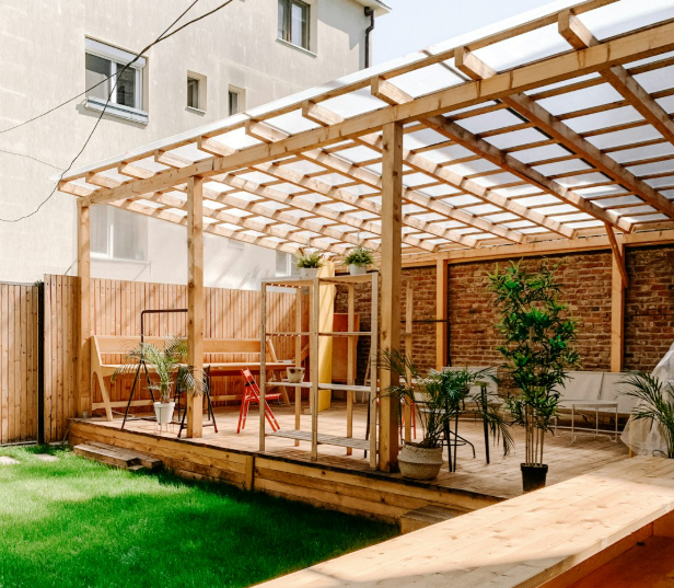 Modern wood pergola with stone wall and greenery in Fort Worth backyard patio
