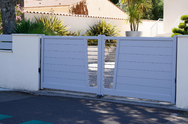Modern light-gray electric driveway gate highlighting budget-friendly installation options offered by Texas Patio and Fence for homeowners seeking affordable automatic gate solutions.