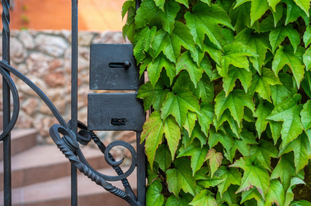 Close-up of electric gate latch and hardware on a residential automatic gate in Fort Worth.