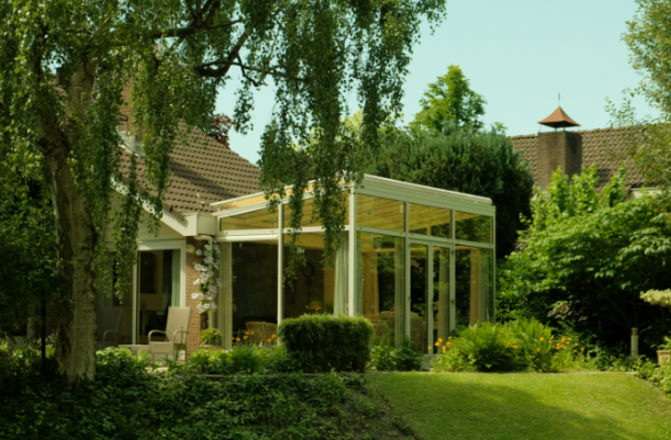 Backyard pergola attached to a home surrounded by greenery in Fort Worth