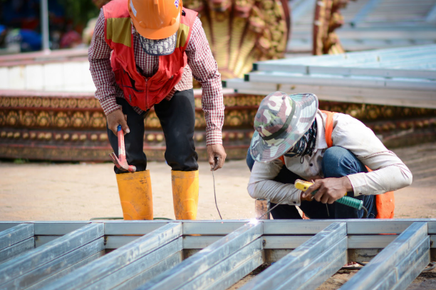 construction workers assembling metal patio framing in fort worth