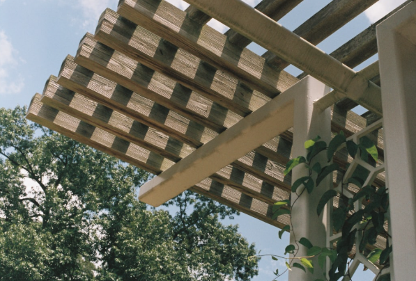 Wood pergola roof detail showing slatted beams and support posts