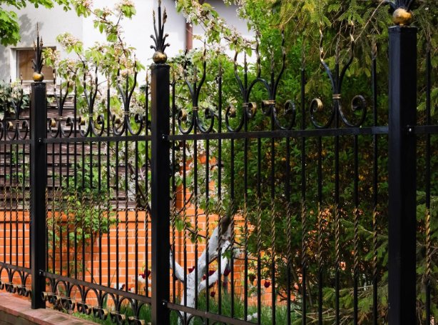 Black wrought iron fence in Fort Worth home garden with decorative metal details